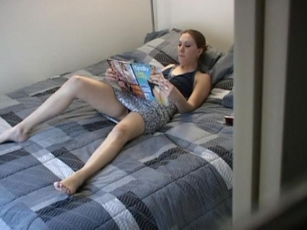 Young girl reading an adult magazine and getting horny in her dormitory without knowing she is being watch.