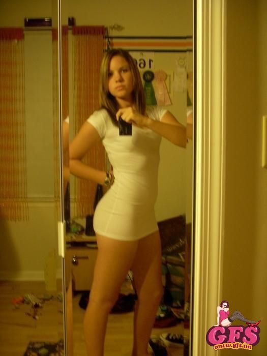 Brunette teen taking a self shot in a sexy tight whit dress