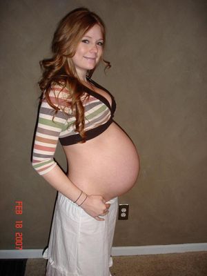 Pregnant sexy redhead posing for a belly shot