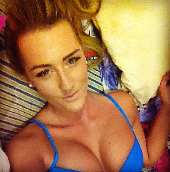 sexy girl laying in bed showing her big tits in her blue bra