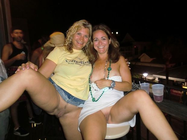 Two naughty wives get a little drunk and show off their pussies in public!