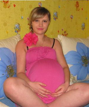 Young pregnant sitting holding her huge belly