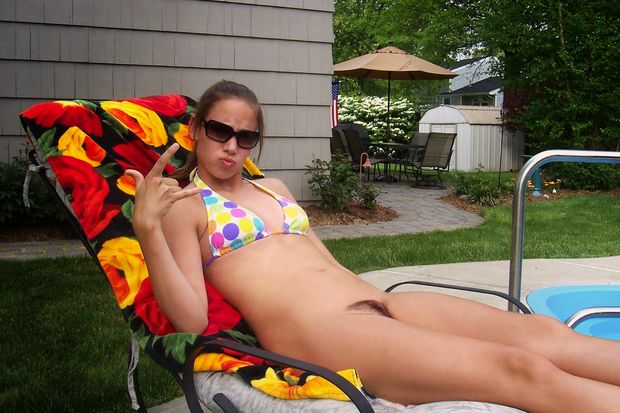 Bottomless bikini babe is annoyed at being disturbed while sunbathing.