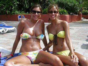 Hot mother & daughter tanning out by the pool