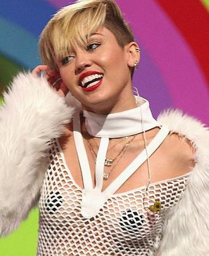 Miley Cyrus without bra under fishnet dress