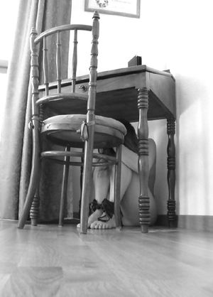 Hiding under the table.