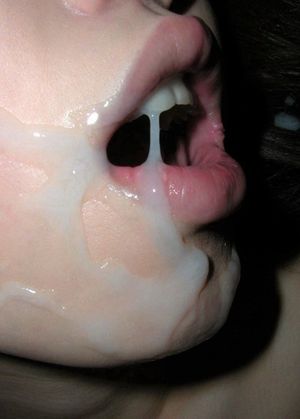 Mouth gaping wide open, she's trying to get cum in her mouth to taste and swallow. A huge wad of cum, dripping down her face and teeth.