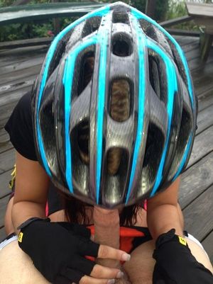 Girl in a bike helmet giving a blowjob