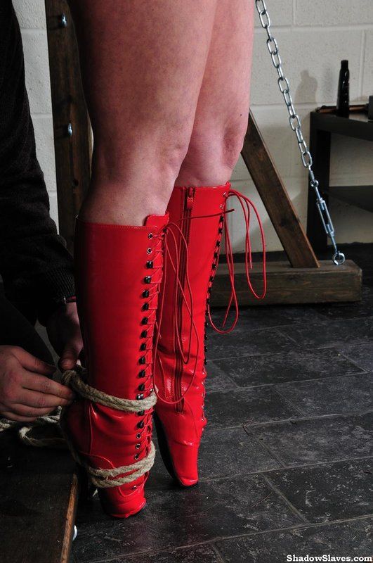 Bondage suspension : Esclave sexuelle mature en cuir rouge et bottines attachée et suspendue
