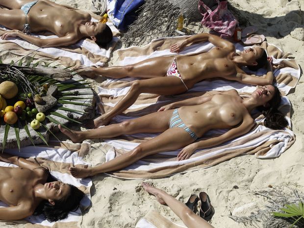 girls sunbathing topless on the beach