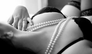 big brunette breasts in black lace lingerie and pearls