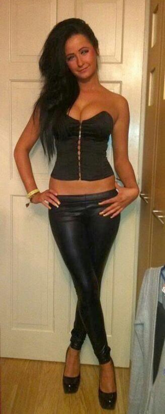 Sexy brunette with big pushed-up tits and tight leather pants