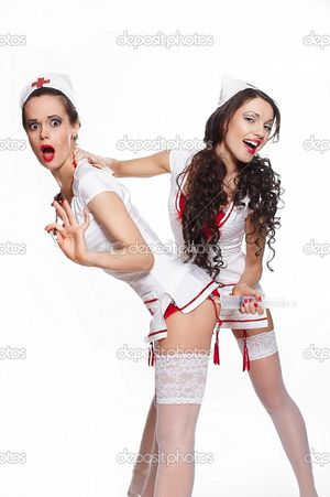sexy nurse in white stockings gives an injection to another sexy nurse in white stockings