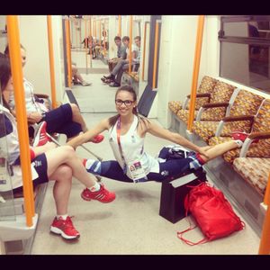 Flexible teen wearing glasses doing splits on subway
