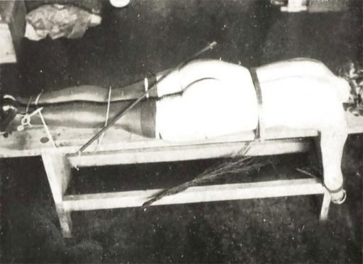 strapped and tied down to a vintage birching bench