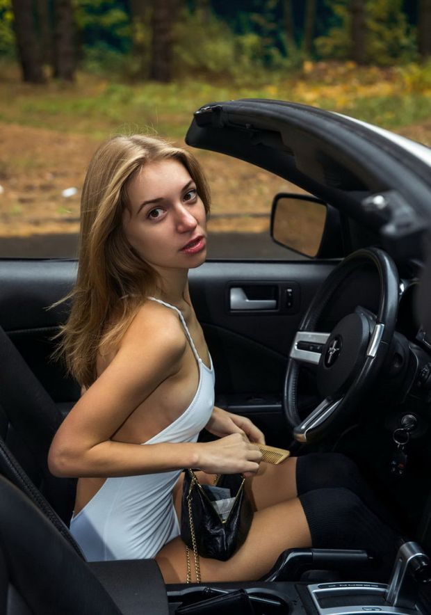 Super sexy blonde in Mustang on the road in the woods