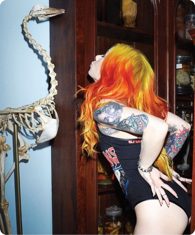 Super red hair babe with amazing tattos on body kissing an Dinosaur Fossils