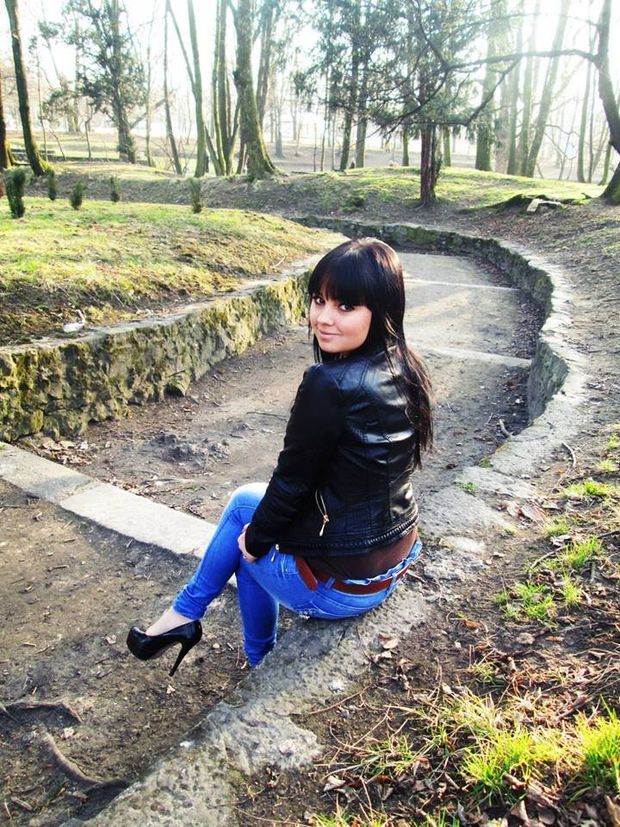 Cute brunette in leather jacket and jeans in the park