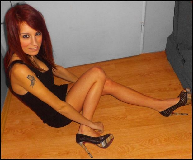 Hot redhead is ready to have fun behind the couch