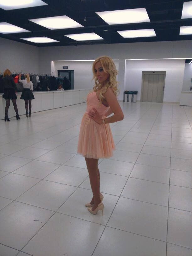Blonde bimbo in pink dress in bright hallway