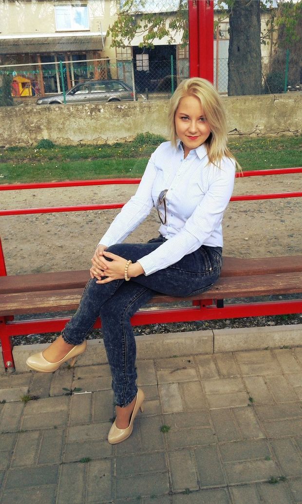 Blonde chick sitting  at the bus stop
