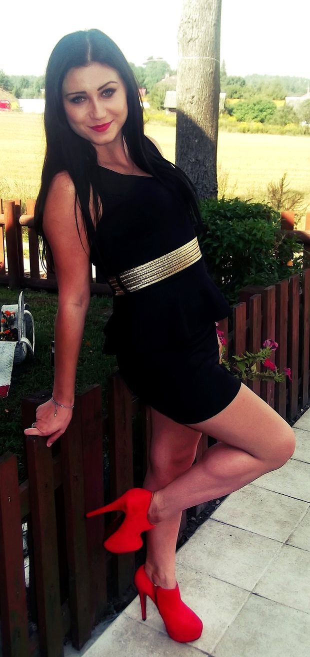 Sexy dolled up brunette in short tight minidress and high heeled red ankle boots