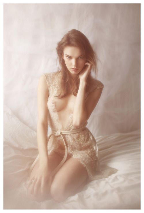 Cute brunette with piercing eyes kneeling in lingerie