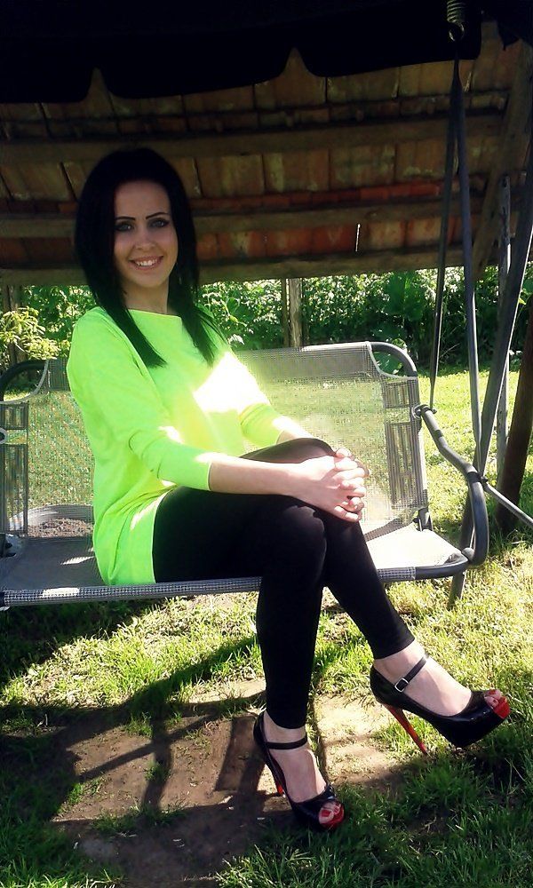 Tanned brunette sitting on a bench in black joga pants and tstrap peeptoe black heels