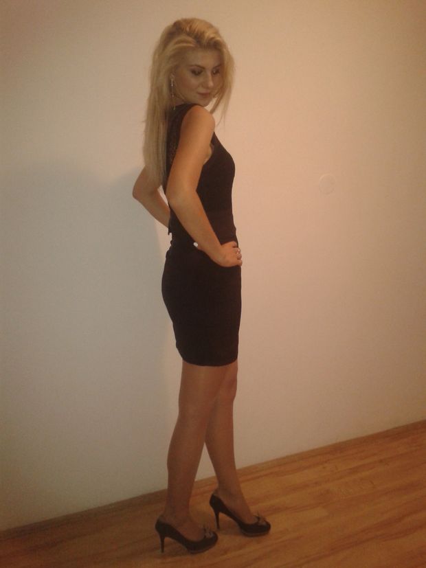 Sexy blonde in tight black dress posing