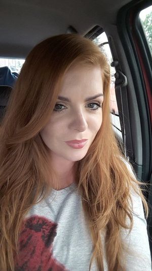 Dolled up redhead chick in a car