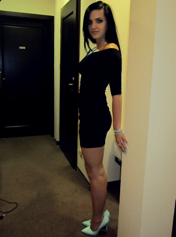 Dark hair bimbo in tight black dress and stilettos