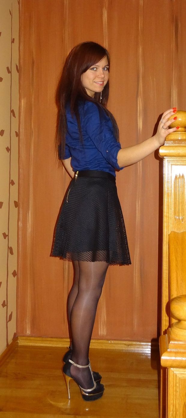 Very pretty young girl in shiny nylon stockings, black mini skirt, silk blue blouse and black'n golden high heeled sandals