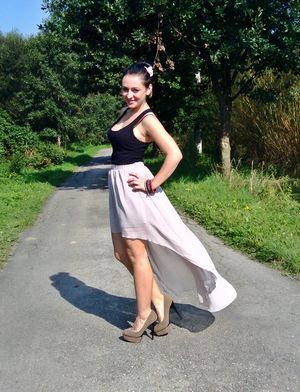 Busty brunette on the road wearing long skirt and platform pumps