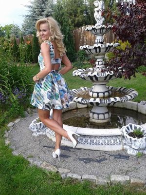 Cougar blonde milf outdoors in short dress and white high heels