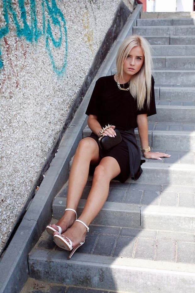 Young blonde chick posing in sexy outfit outdoors on the stairs