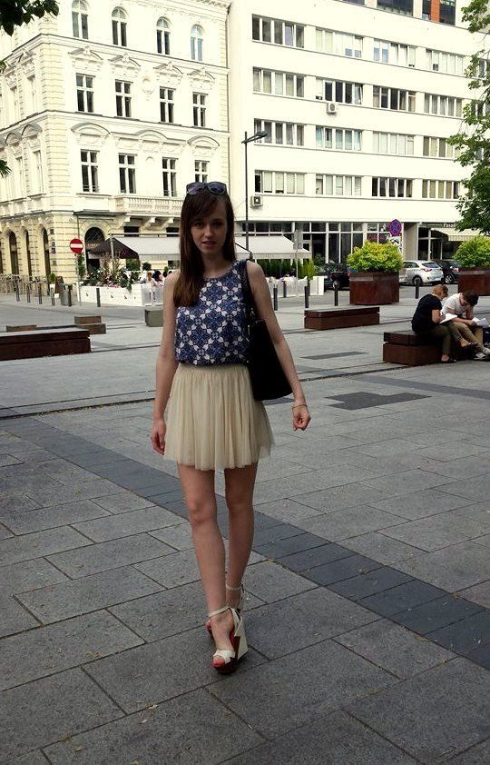 Cute young eighteen wearing see thru mini skirt and high wedges, outdoors