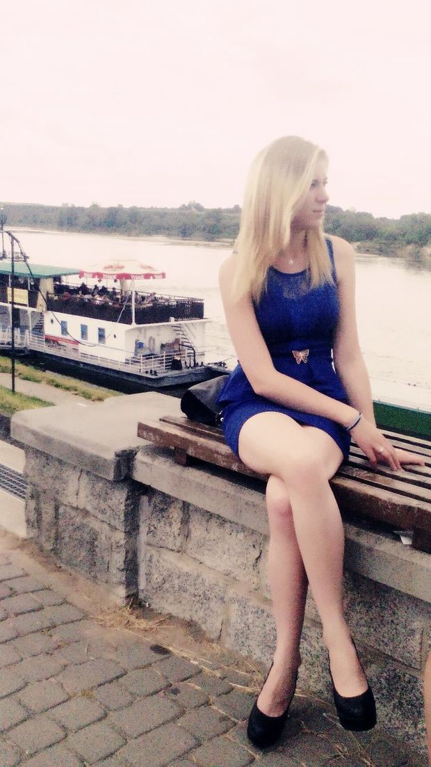 Leggy blonde in tight mini blue dress and black high heeled platforms outdoors
