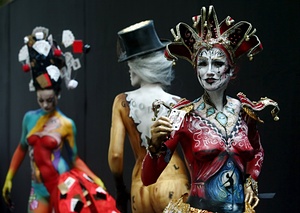 Curtains up: a ballet dancer performs on the stage below the curtains of a theatre painted on this model, who crowns her artwork with a jester’s hat.