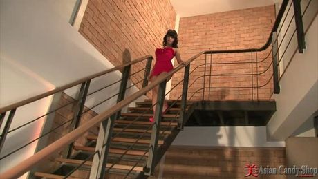 Sex kitten nuch approaches the stairs and descends as she strips off her to show her tits and tight Asian pussy.