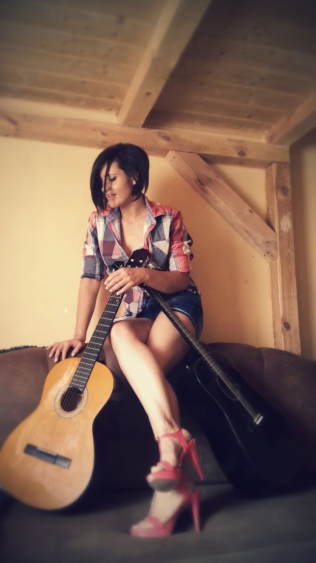 Sexy brunette posing with her guitars