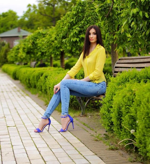 Hot brunette posing on a park bench