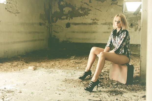 Blonde model revealing her beautiful long legs inside some abandoned building