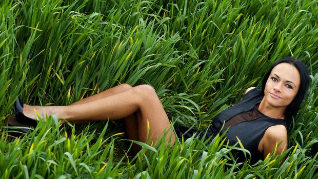 Tanned brunette posing in grass