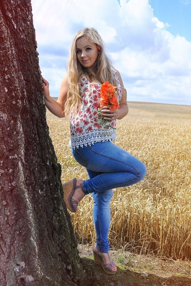 Cute blonde posing outdoors on the wheat field