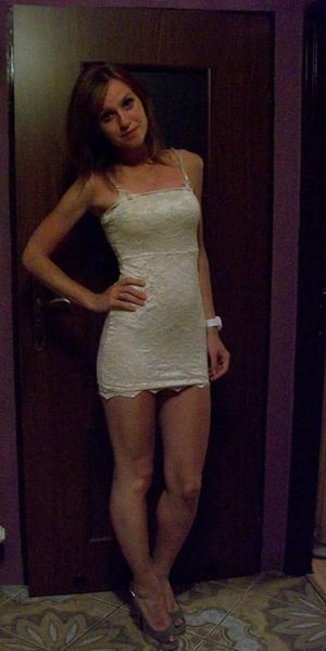 Cute and little bit shy blonde chick posig in tight mini dress