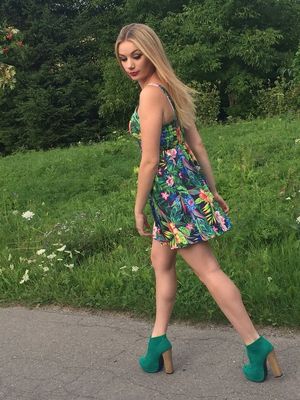 Nice, leggy blonde walking through the park in summer mini dress