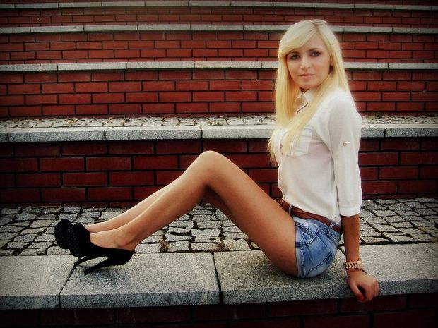 Blonde chick in tight jeans shorts posing outdoors