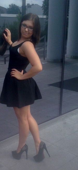 Teasing outdoors in mini black dress and high heels