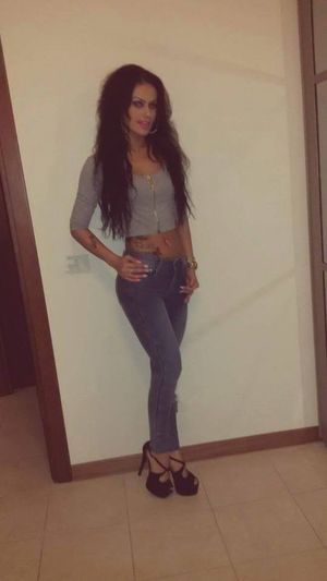 Tanned bimbo posing in high heels and tight jeans