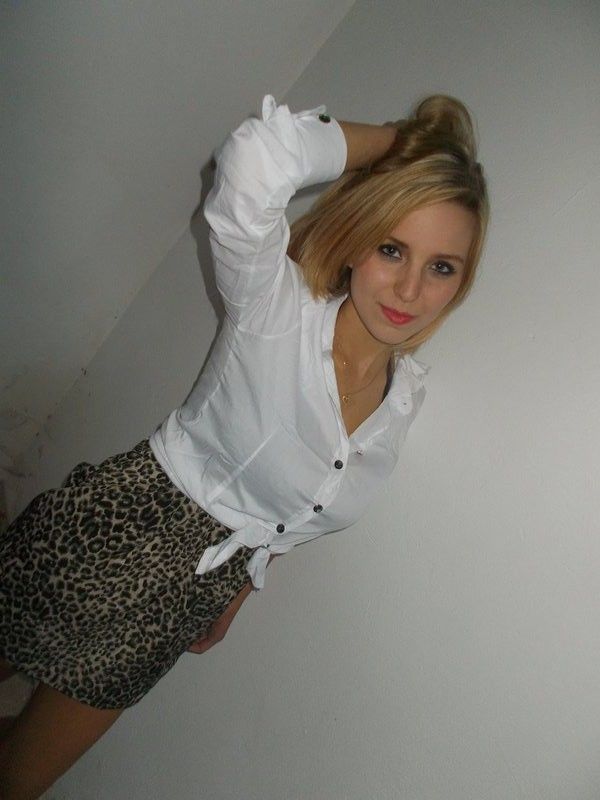 Cute blonde girl in mini skirt and white shirt